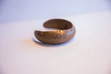 The simple, rounded form and time-softened patina of an antique African bracelet.