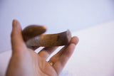 Rich, time-worn patina on the handcrafted surface of an antique African cuff.