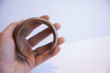 Antique African cuff bracelet held in hand, showing its simple shape and scale.