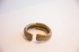 Angled view highlighting the handcrafted texture of the vintage African bronze cuff.