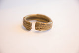 Hand-worked details and aged patina at the opening of a vintage bronze cuff.