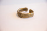 Angled view of a vintage bronze cuff showing its braided texture and aged patina.