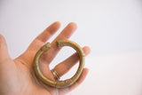 Vintage African bronze cuff held in hand to show its scale and aged patina.