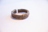 Side view of the vintage bronze cuff showing its textured patina and open design.