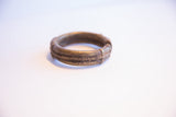 Side profile of the vintage African bronze cuff showing its textured bands and patina.