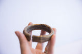 Interior curve and aged patina of a handmade vintage African bronze cuff.