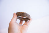 The handcrafted texture and aged patina of a vintage bronze cuff held in hand.