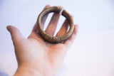 Collectible African bronze cuff bracelet resting in a palm, showing its scale.