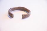 Vintage African copper alloy bracelet showing its open form and squared, etched ends.