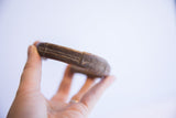 Side view of a thick vintage African copper cuff showing its aged patina and etched details.