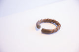 The handcrafted twisted metal and open shape of an antique African cuff bracelet.