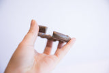 Hand holding the antique twist design cuff, showing its opening and solid ends.