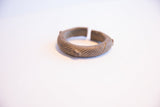 Profile view of an antique African bronze bracelet's cuff opening and textured surface.