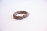 Profile of the antique bronze cuff bracelet showing its open ends and patina.