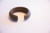 A heavy antique African cuff bracelet with a deep patina and incised details.