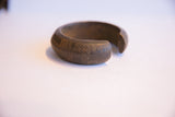 Etched details and time-softened patina on the curved side of an antique African bracelet.