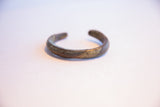 Angled view of the vintage African cuff highlighting its oxidized texture and open design.
