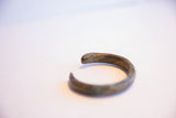Close view of the cuff's smooth terminal showing its aged metal patina.