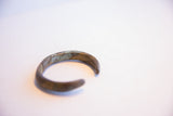 Visible seams and oxidized patina on the handmade African barber pole cuff.