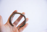 Vintage African cuff bracelet held in hand to illustrate its size and curved shape.