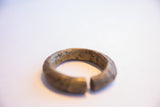 Angled view of the vintage African bronze cuff showing its textured, worn patina.