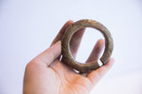 Vintage African bronze alloy cuff bracelet held in hand to show scale and texture.