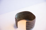 Angled view into the vintage cuff showing the oxidized patina on its inner surface.