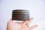 Hand holding a vintage African cuff bracelet to show its scale and rich patina.