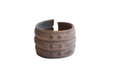 Vintage wide African cuff bracelet with three raised bands and a textured, dark aged patina.