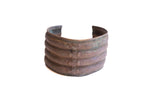 Vintage African wide cuff bracelet with four bands, a studded center, and a dark patina.