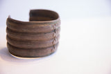 Angled view of the vintage African cuff highlighting its tiered form and patina.