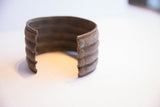 The open back and banded metal layers of a vintage African wide cuff bracelet.