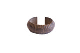 Vintage African cuff bracelet with a wide, ribbed body and dark, oxidized patina.