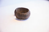 Detailed view of the handcrafted ribbed texture on the vintage African cuff.