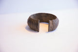 Opening of the textured vintage African cuff bracelet, revealing its aged metal patina.