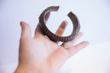 Vintage African cuff bracelet held in a hand to show its scale and shape.