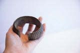 Vintage African cuff bracelet with a deep patina held in an open palm.