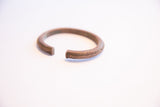 The ridged texture and solid, squared-off ends of the vintage African cuff bracelet.