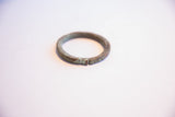 The open cuff and textured, time-softened patina of a handmade African bracelet.