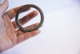 The circular form and time-worn textured patina of a vintage African bracelet.