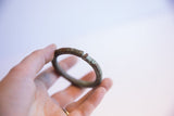 Detail of the oxidized patina and open ends of a vintage African bracelet.