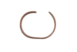 Vintage African cuff bracelet with a simplistic flat band and dark, time-softened metal patina.