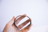 The vintage African cuff bracelet held to show its simple form and scale.