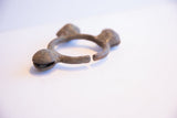 Side profile of the oxidized Lobi bell cuff showing its open shape and rugged texture.