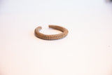 Angled view of a vintage African cuff highlighting its rustic ribbed texture.