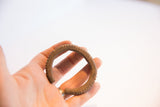 In-hand view of the vintage African cuff's notched texture and oxidized patina.