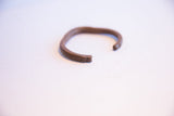 Angled view of the vintage copper cuff showing its opening and texture.