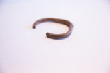 Detail of the handmade African cuff showing its solid, squared-off copper end.