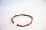 Hand-twisted metal showing the rustic, aged patina on the vintage African cuff.