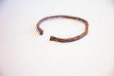 Angled perspective of the vintage African cuff's twisted form and aged patina.
